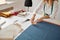 Dressmaker measures cloth at workplace in workshop