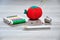 A dressmaker pencil with an out of focus pin cushion shaped as a red tomato, rolls of thread and a thimble