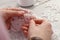 Dressmaker working with beautiful white lace at table in atelier, closeup