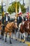 Dressy riders on beautiful well-groomed horses carry US flags