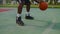 dribbling on basketball open ground, closeup of legs and hands of black sportsman, streetball