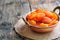 Dried apricot in a copper bowl on the old wooden background