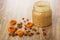 Dried apricots, raisin, peanut butter with fruits in transparent jar on wooden table