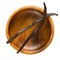 Dried Bourbon vanilla pods over empty wooden bowl