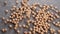 Dried brown chickpeas falling in a heap on a gray rough jute rustic mat