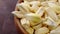 Dried cancha corn kernels falling into a wooden rustic bowl