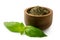 Dried chopped basil in a dark wood bowl next to fresh basil leaves isolated on white