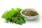 Dried chopped provence herbs in a white ceramic bowl next to fresh bouquet garni isolated on white