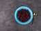 Dried cranberries in blue bowl. Healthy tasty dry red berries spoon. Organic nutritious delicious farmers fruits snack