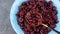 Dried cranberries in blue bowl top view. Organic nutritious Healthy tasty dry red berries spoon