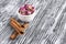 Dried damask rose buds in small bowl and cinnamon sticks on black wooden table.