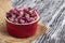 Dried damask rose buds in small r.ed bowl on black wooden table