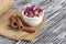 Dried damask rose buds in small white bowl and cinnamon sticks