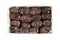 Dried dates arranged in rows in a cardboard box on white background. View from above