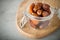 Dried dates in a glass jar on a light grey marble table