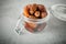 Dried dates in a glass jar on a light grey marble table