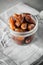 Dried dates in a glass jar on a light grey marble table