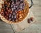 Dried dates in wicker basket on a wooden background, top view