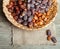 Dried dates in wicker basket on a wooden background, top view