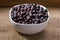 Dried elderberries in small white bowl
