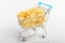 Dried Farfalle Rigate Italian pasta in a grey store trolley bowl ready to be cooked, isolated on a white table, top view or flat l