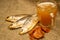 Dried fish, dried caviar and a beer mug on a homespun cloth with a rough texture. Close up