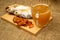 Dried fish, dried caviar, and a beer mug on a wooden serving Board. Close up