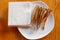 Dried fish strung on a wooden skewer lies on a plate