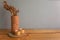 The dried flowers in earthen vase put on the wood table and gray wall