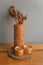 Dried flowers in earthen vase put on the wood table and gray walls