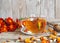 Dried flowers of red flowers black-haired or golden Mary, Turkish carnation with a cup of medicinal tea on a wooden background.