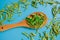 Dried and fresh stevia leaves in a wooden spoon on a blue background.Stevia rebaudiana.Alternative Low Calorie Sweetener