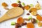 Dried fruits and nuts, apricot, almond, hazelnut pear prune and macadamia with bamboo wooden spoon on white background.