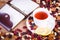 Dried fruits with white cup of tea, saucer and notebook