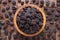 Dried grapes, dark raisins in wooden bowl, top view