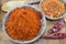 Dried grounded, chopped and whole peppers in natural wooden bowl