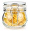 Dried italian pasta spiral Fusilli in a closed transparent glass jar with rubber seal and metal clamp on lid isolated on white