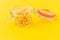 Dried italian pasta spiral Fusilli in a open glass jar on yellow background