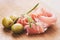 Dried jamon slices with olives and rosemary on wood table