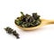 Dried leaves of Betonica officinalis lie in a wooden spoon on a white background