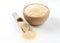 Dried milled ground garlic in wooden bowl and scoop isolated on white background. Spices and food ingredients