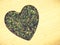 Dried nettle leaves heart shaped on wooden surface