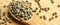 Dried okra seeds in wooden spoon, on bamboo cutting board