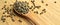 Dried okra seeds in wooden spoon, on bamboo cutting board