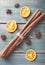 Dried orange, anise and cinnamon sticks on green wooden table.