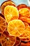 Dried orange slices chips background. Dehydrated crispy fruit pieces. Lots of dried crispy oranges. Healthy food, snack.