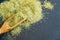 Dried oregano herbs in wooden spoon. Natural light. Selective focus. Close up on a black background. Top view, flat lay