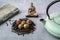 Dried Organic Black Tea Leaves and aromatic green tea flowers on gray Background. Composition with Iron teapot, linen
