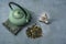 Dried Organic Green Tea Leaves with herbs and fruits on gray Background. Composition with Iron teapot, linen cloth and