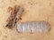 Dried palm trunk bark on white sand. Background of biodegradable nature remains. Palm tree waste texture